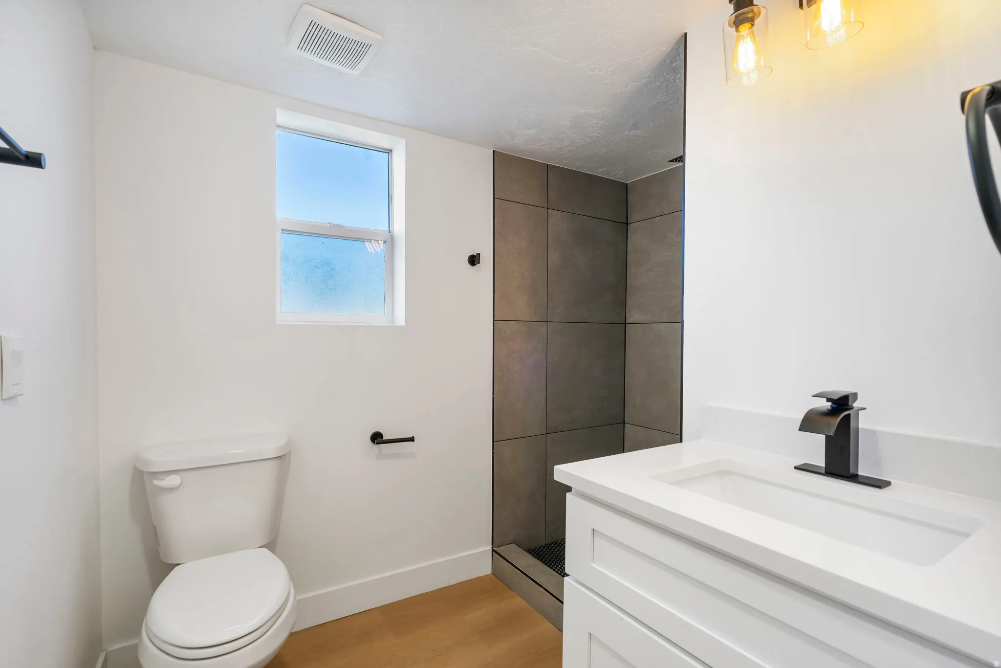 Bathroom with vanity, a shower stall, and light wood finished floors