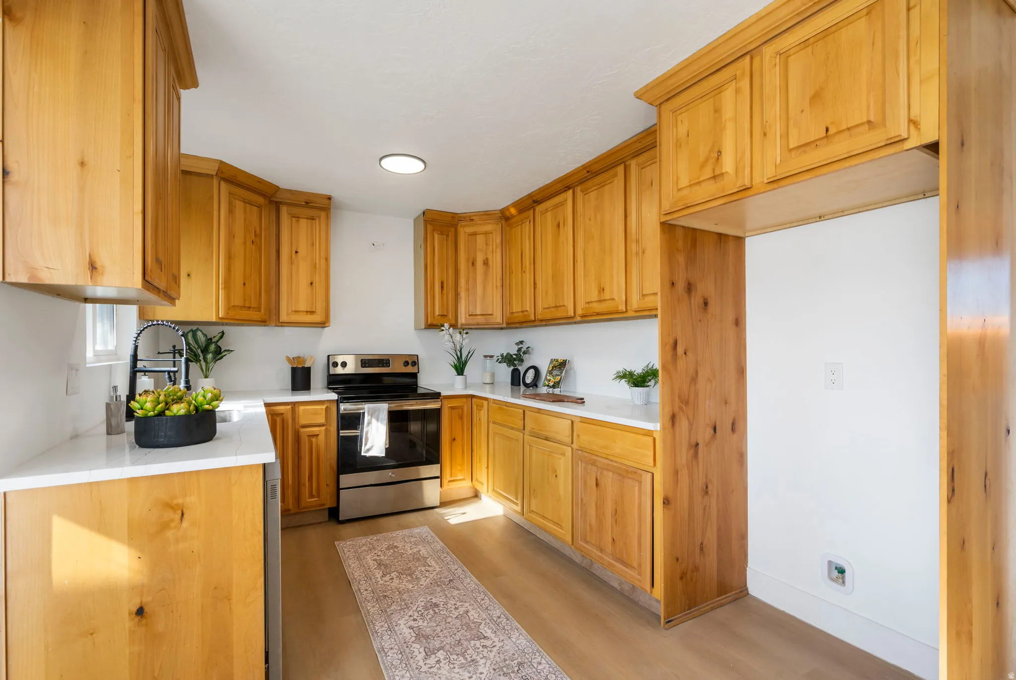 Kitchen featuring stainless steel range with electric cooktop and light wood finished floors