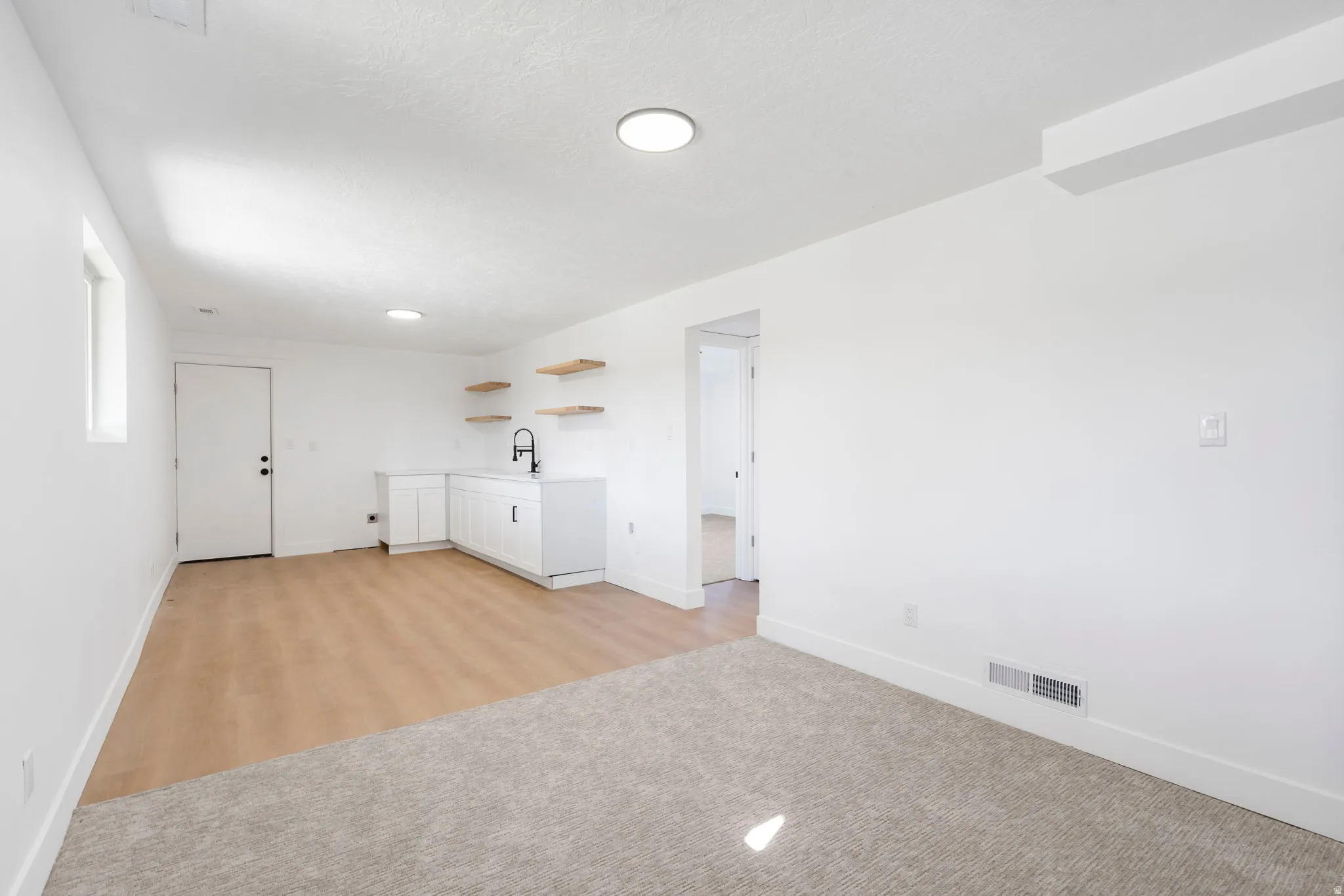 Empty room with light carpet and baseboards