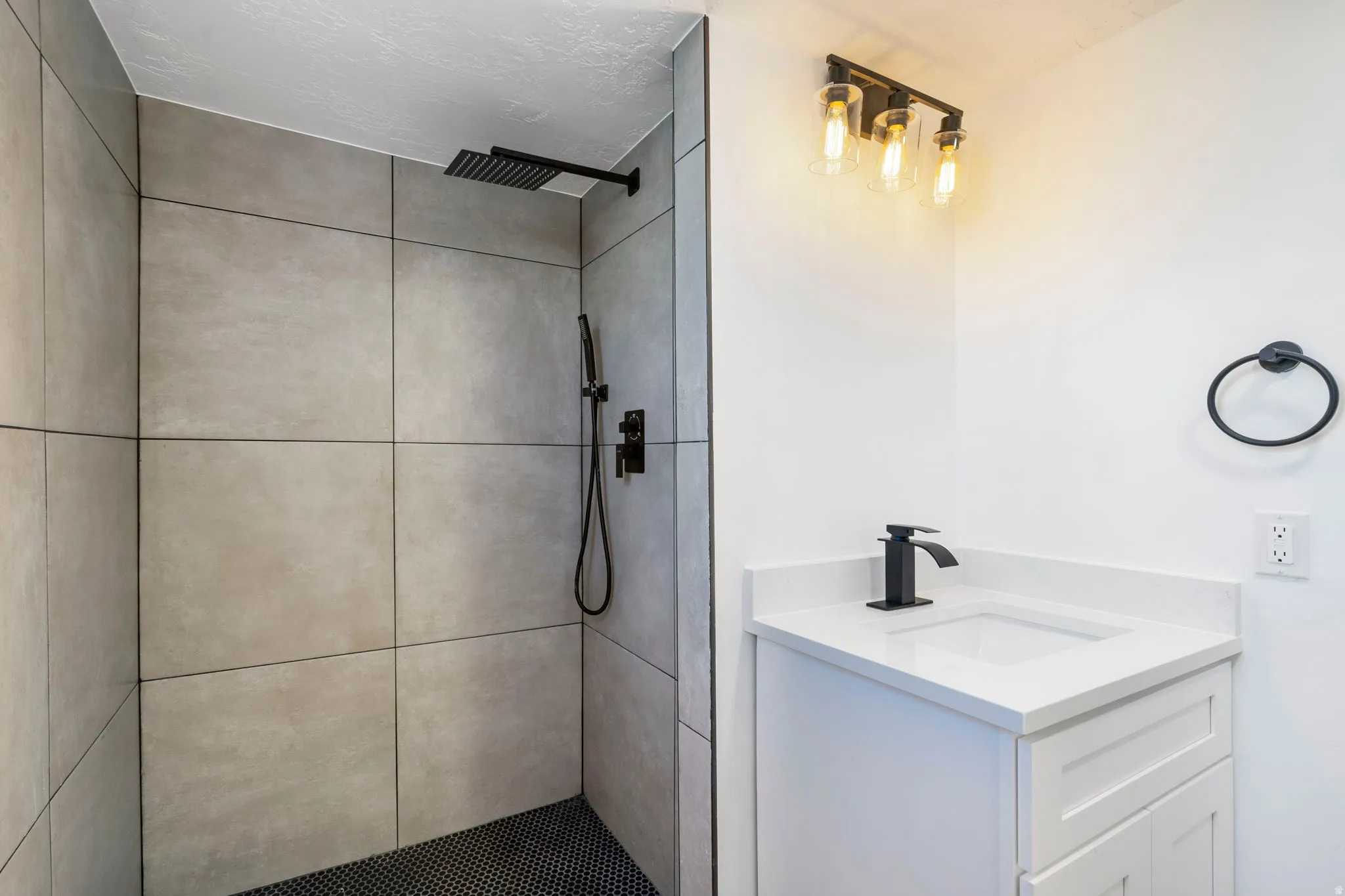 Bathroom featuring vanity and tiled shower
