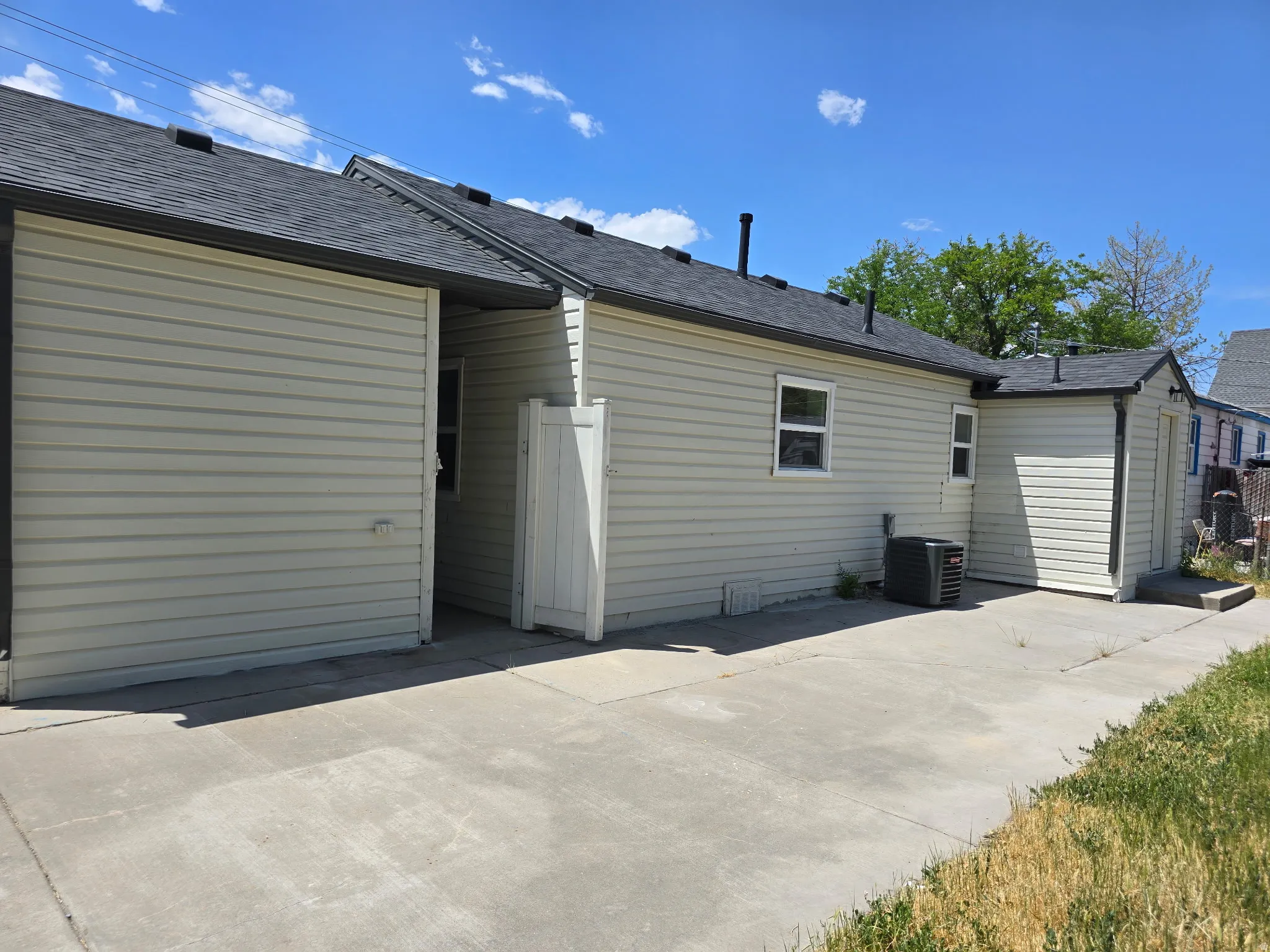 Rear view of house with a shingled roof and a patio
