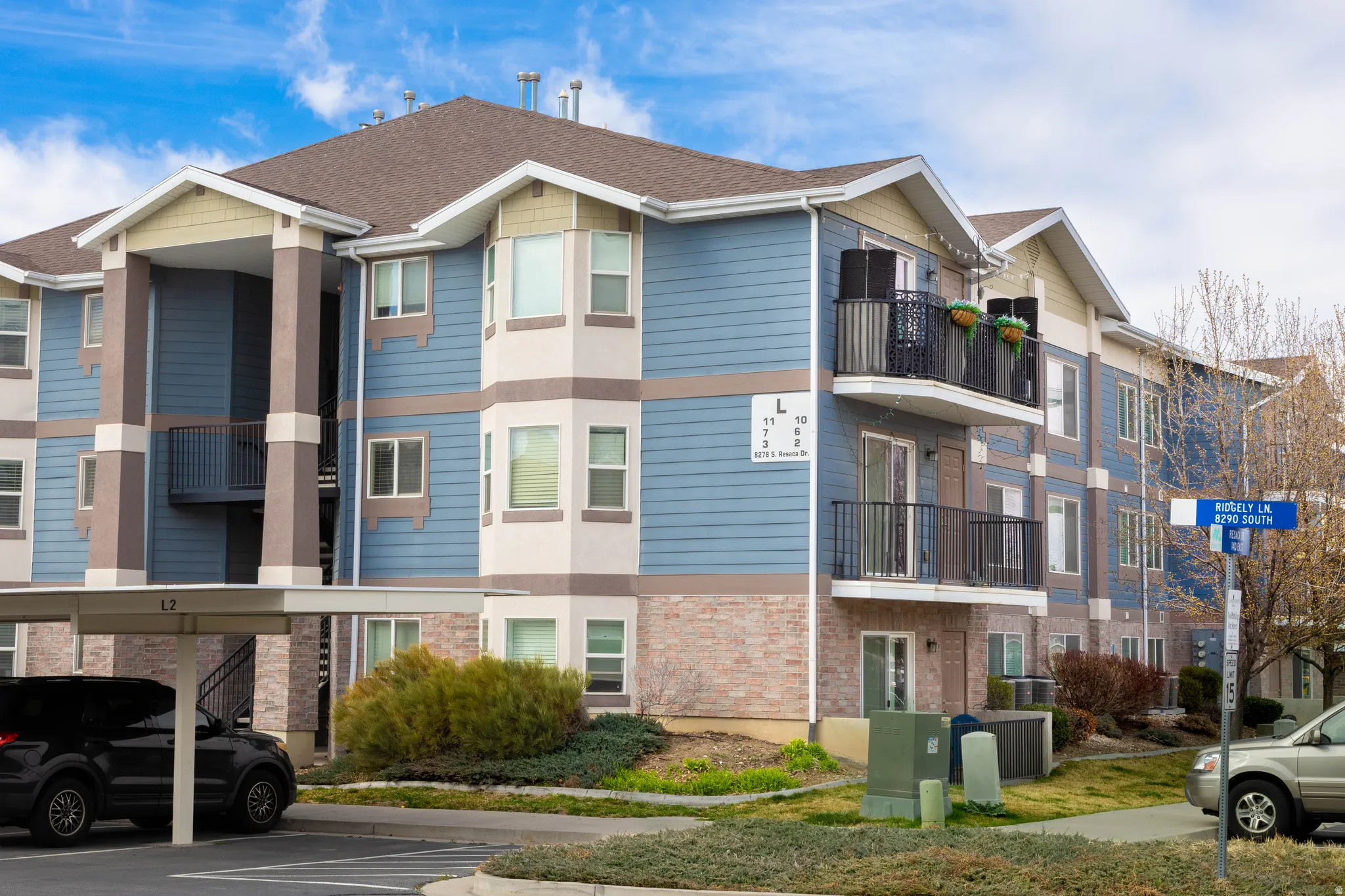 View of apartment building / complex featuring covered parking