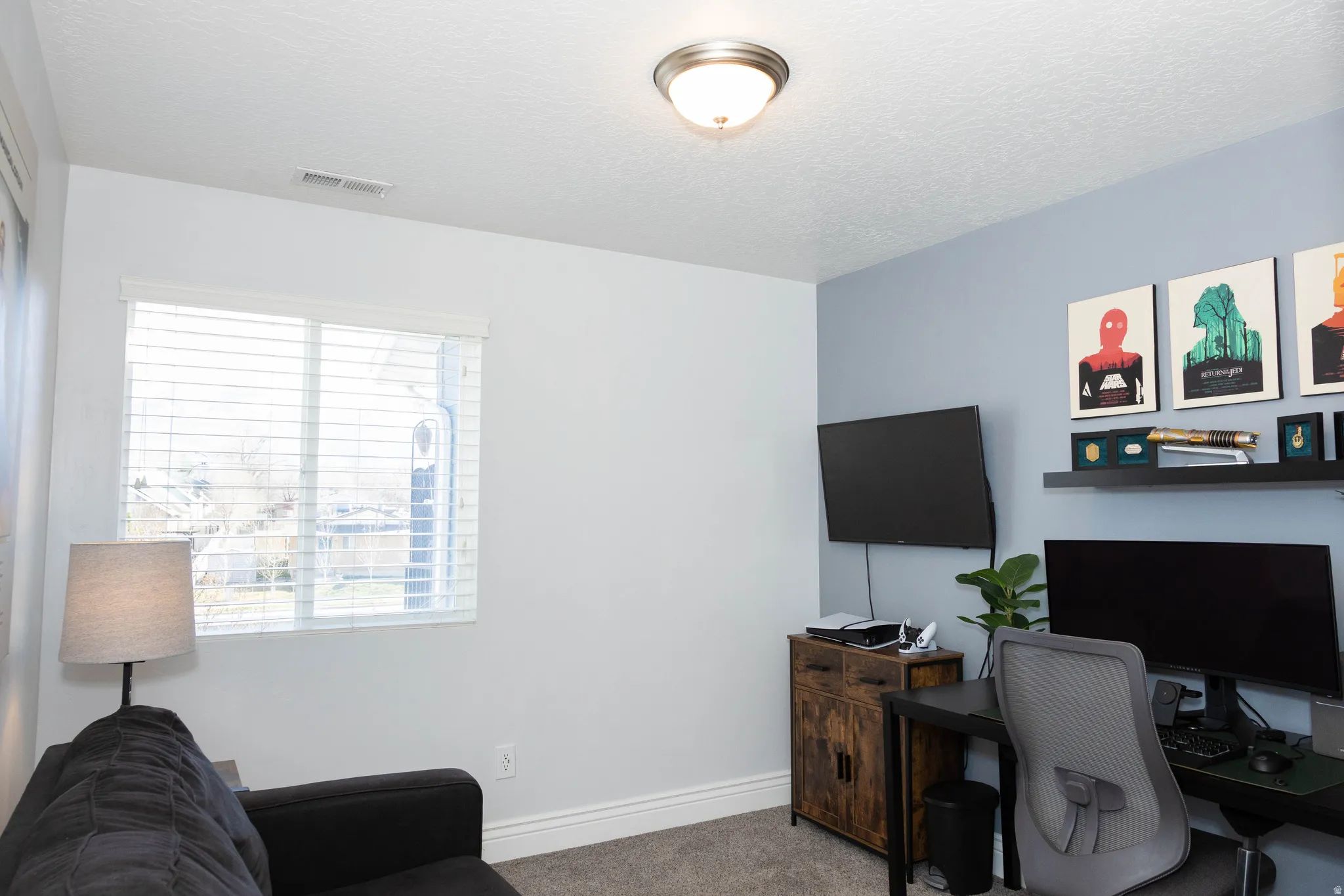 Office area featuring carpet and a textured ceiling