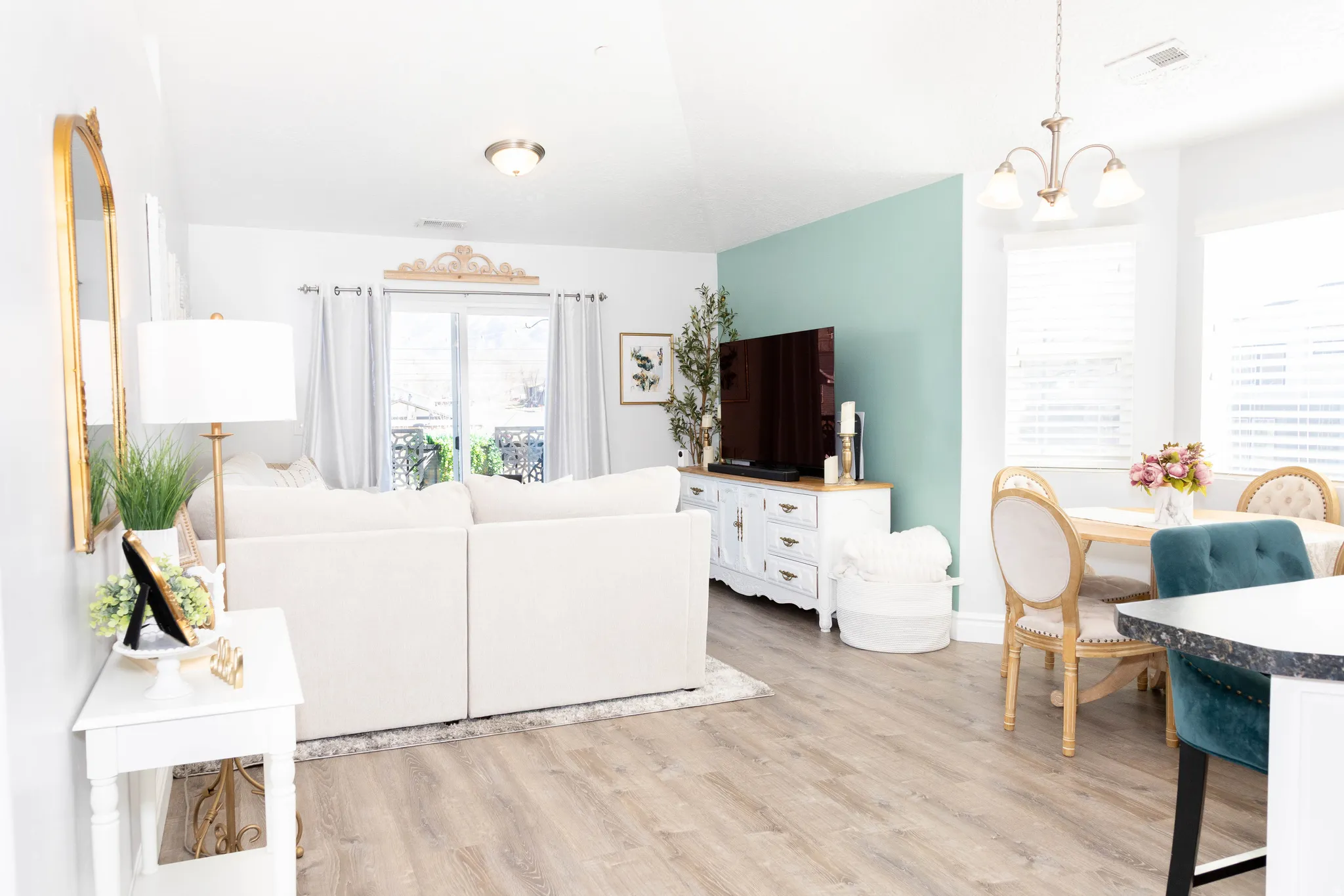 Living room with light wood-type flooring and suspended lighting
