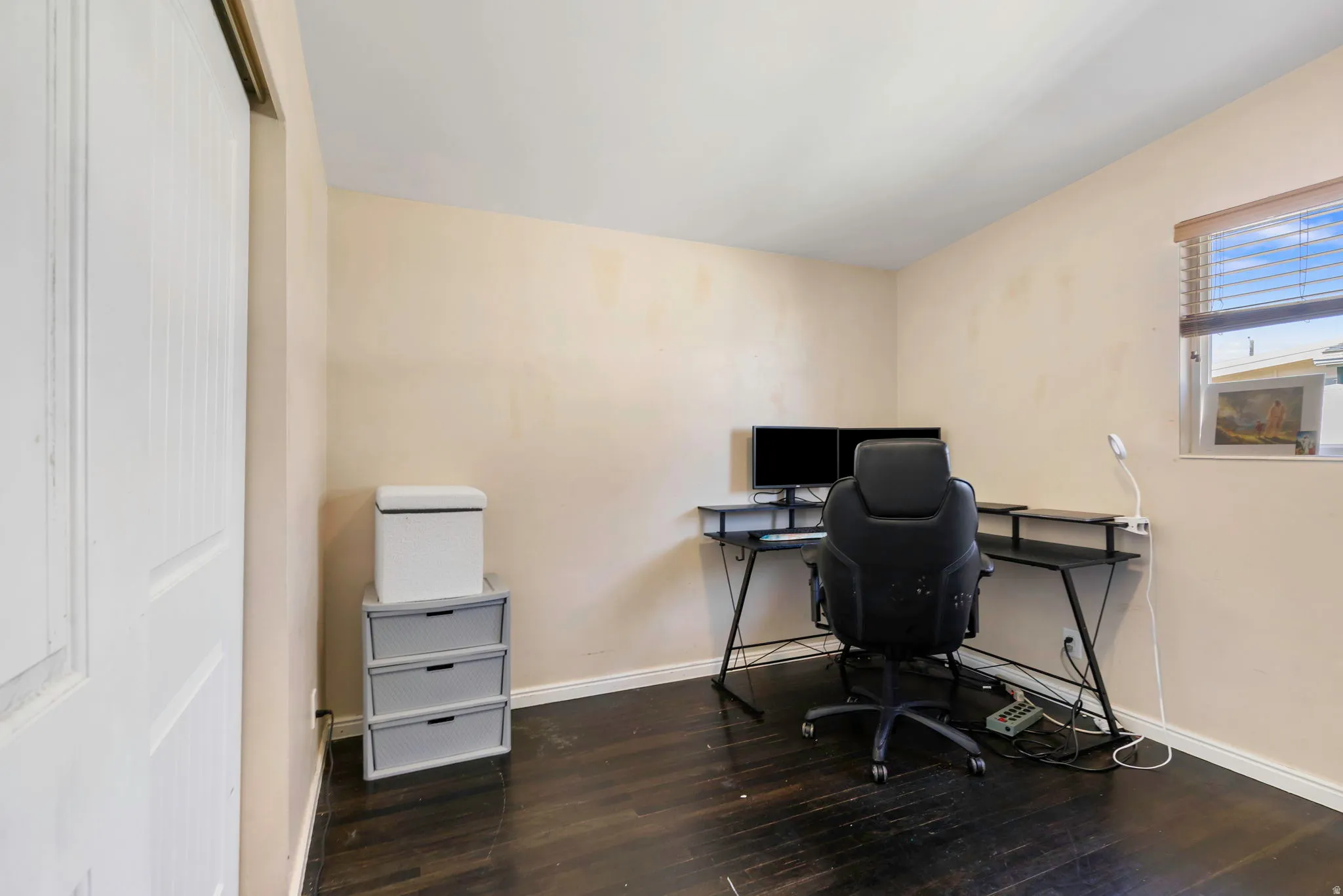Office space featuring dark wood-style floors and baseboards