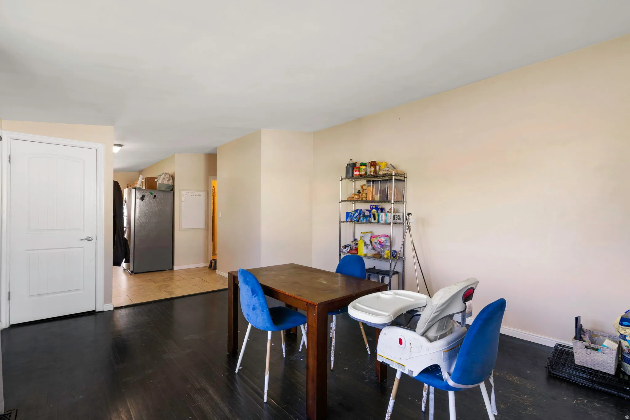 Dining space with dark wood-style flooring and baseboards