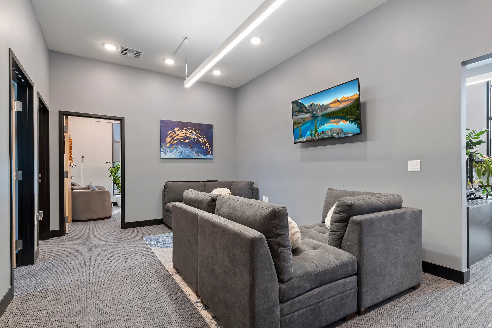 Living area with light colored carpet and recessed lighting