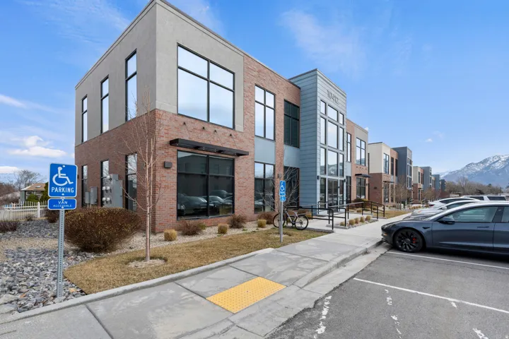 View of building exterior with uncovered parking and a mountain view