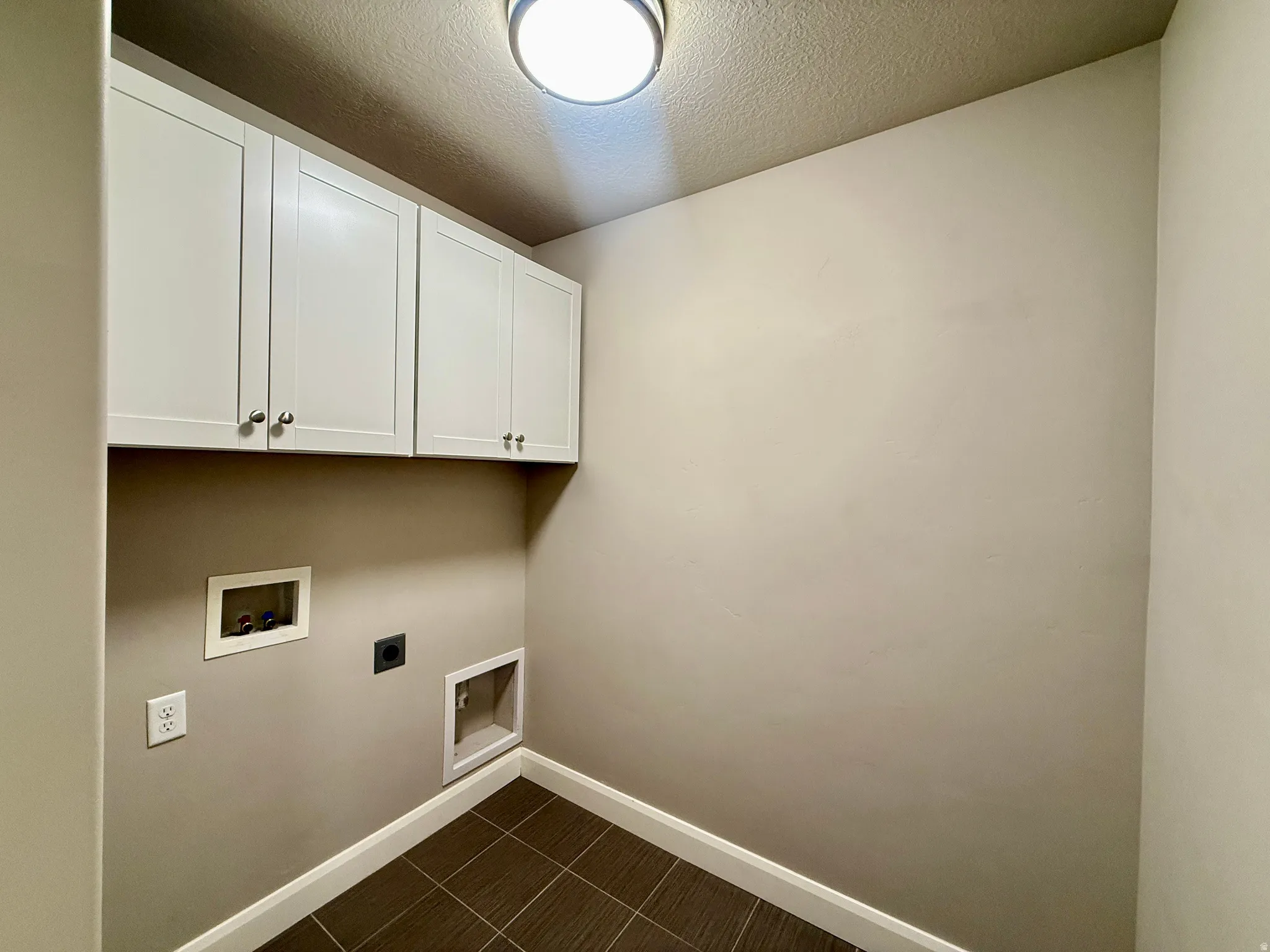 White shaker-style upper cabinetry, recessed lighting, and tile flooring