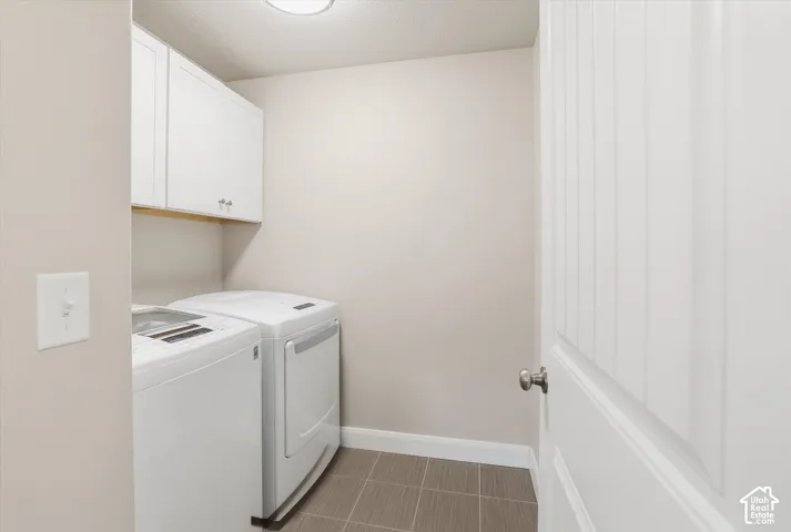 Laundry room with cabinet space, a textured ceiling, and independent washer and dryer