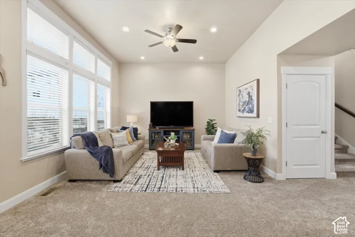 Living room featuring light carpet, ceiling fan, and recessed lighting