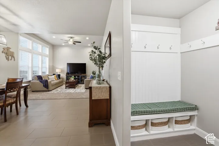 Mudroom with a ceiling fan and light tile patterned floors
