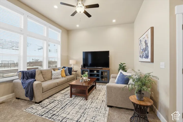 Living room featuring a ceiling fan, recessed lighting, and light colored carpet