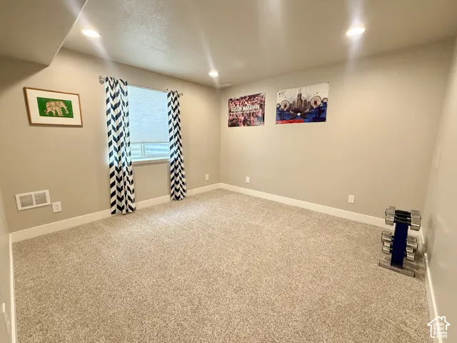 Recessed ceiling lighting, neutral-toned walls, light-colored carpeting, and a single window