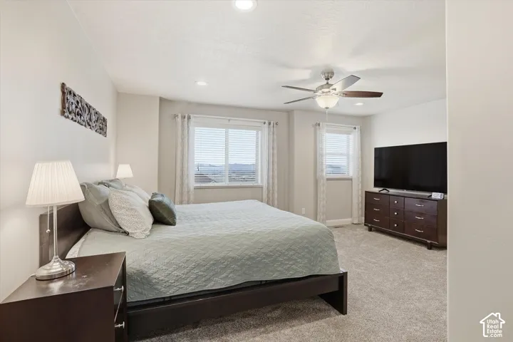 Bedroom featuring light colored carpet, a ceiling fan, and recessed lighting