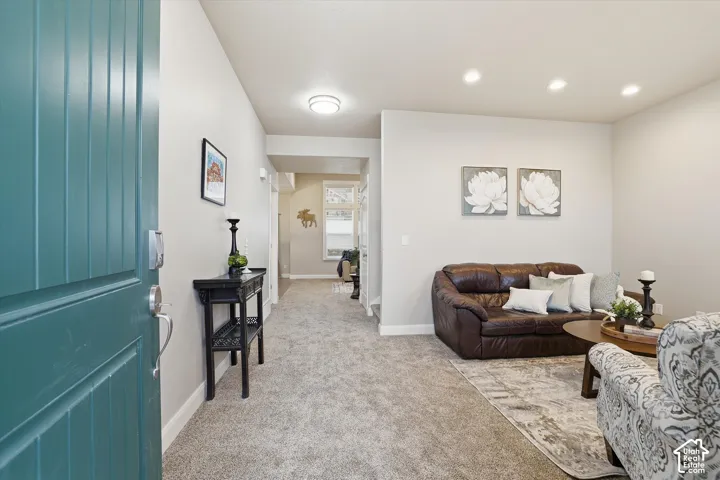 Living area featuring light colored carpet and recessed lighting