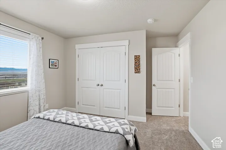 Bedroom featuring carpet and a closet