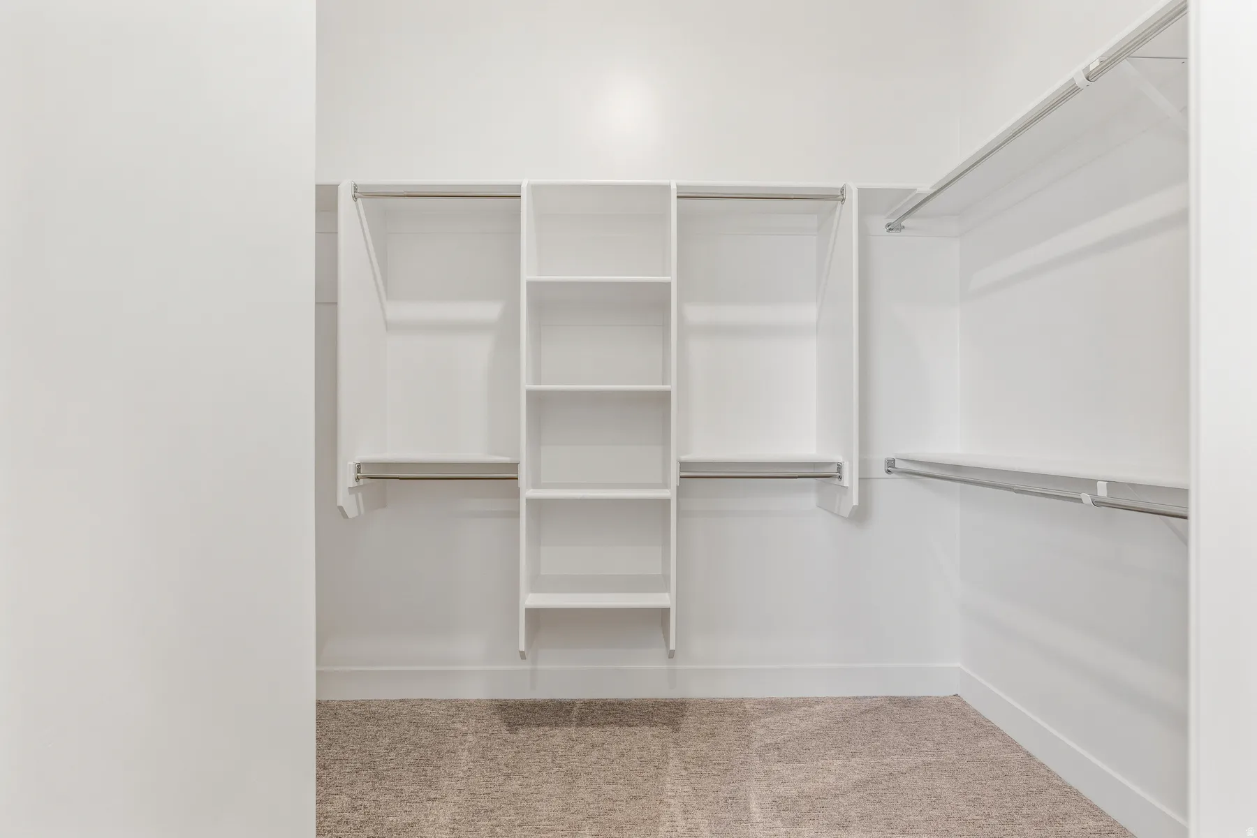 Walk in closet with light colored carpet
