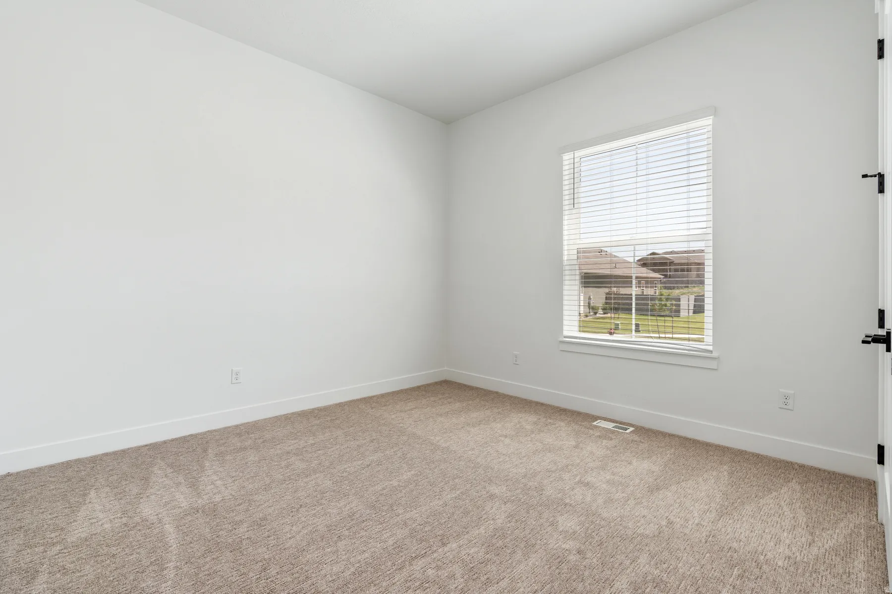 Carpeted empty room with baseboards