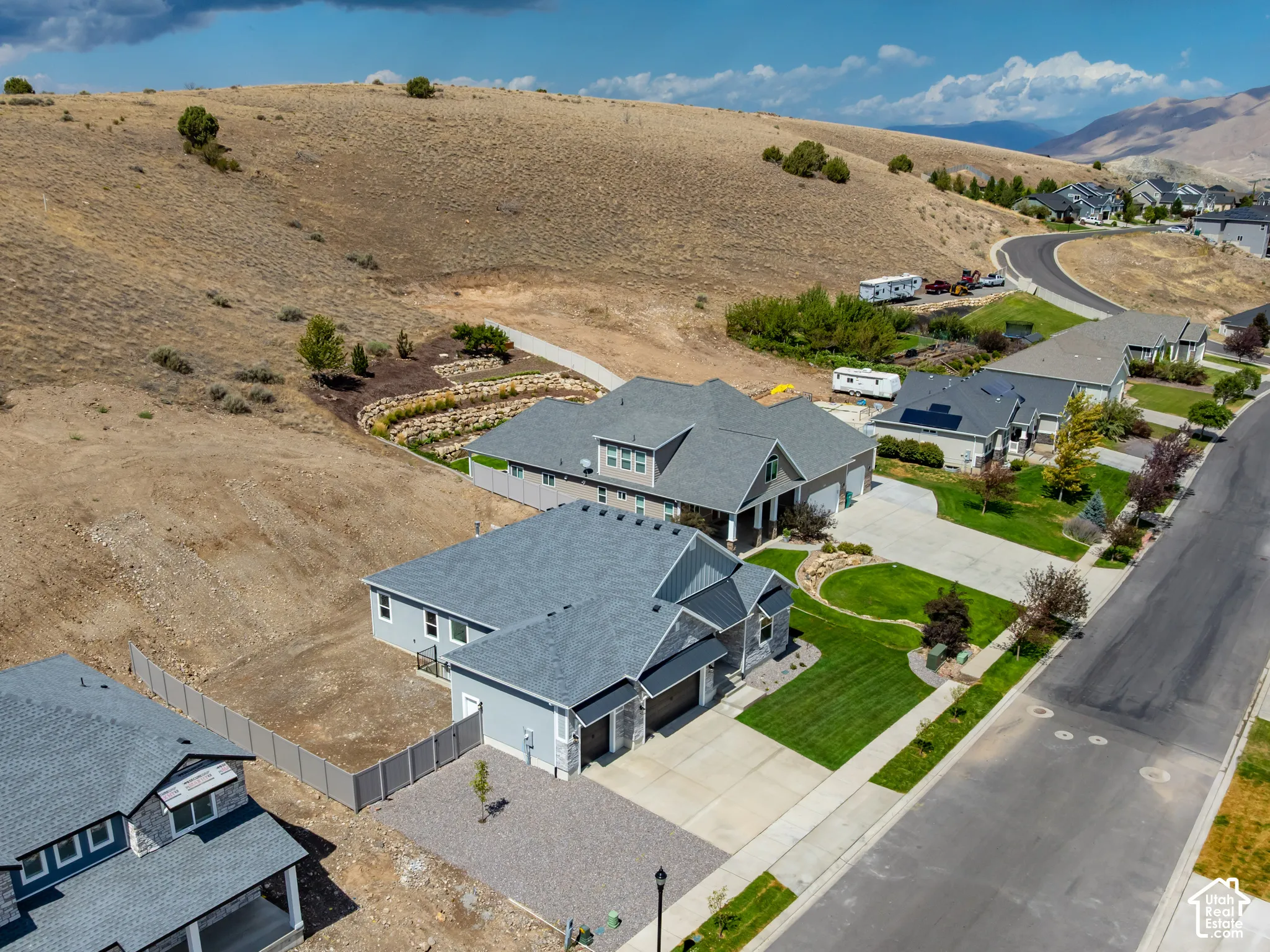 Contemporary residence with a gray shingle roof, attached two-car garage, and a gravel driveway
