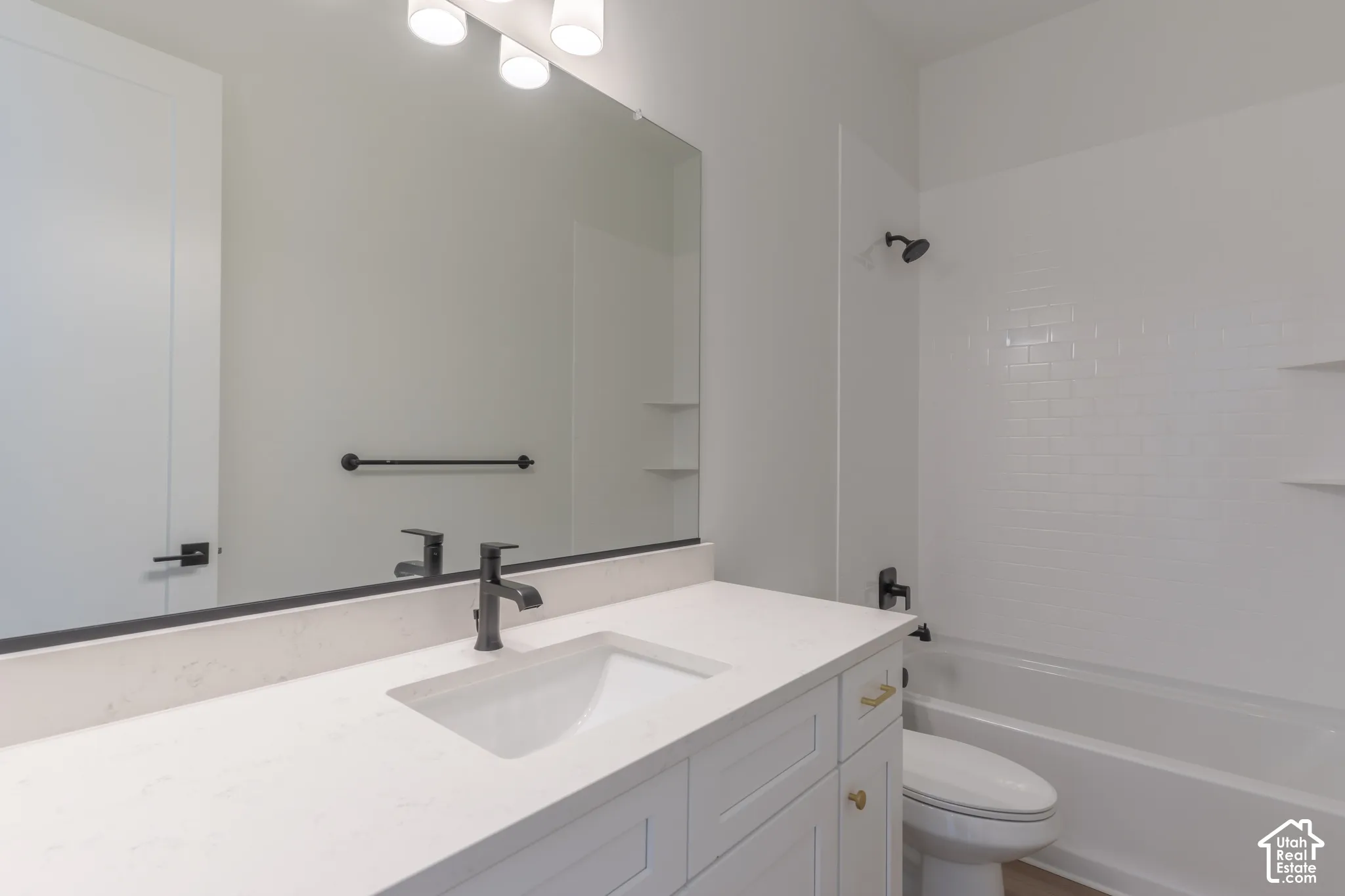 Vanity with an integrated sink, matte black faucet, and light-toned countertop