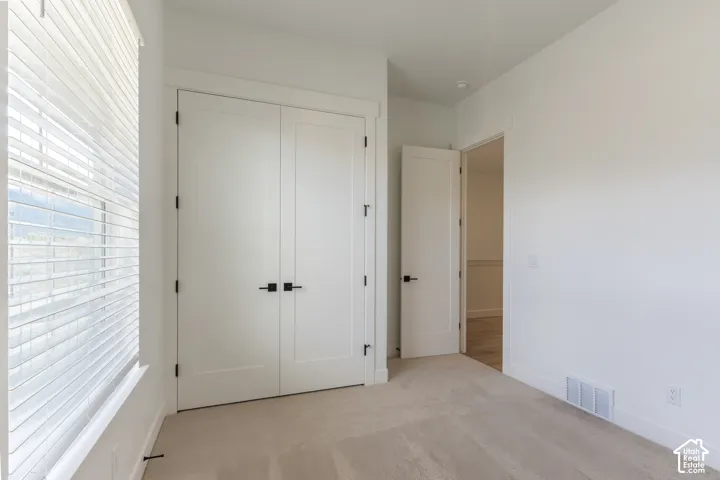 Wall-to-wall carpeting with white walls, white trim, and a white ceiling