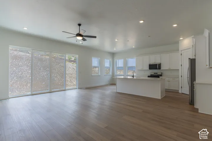 Open-concept living space with wood-finish flooring, recessed lighting, and a ceiling fan