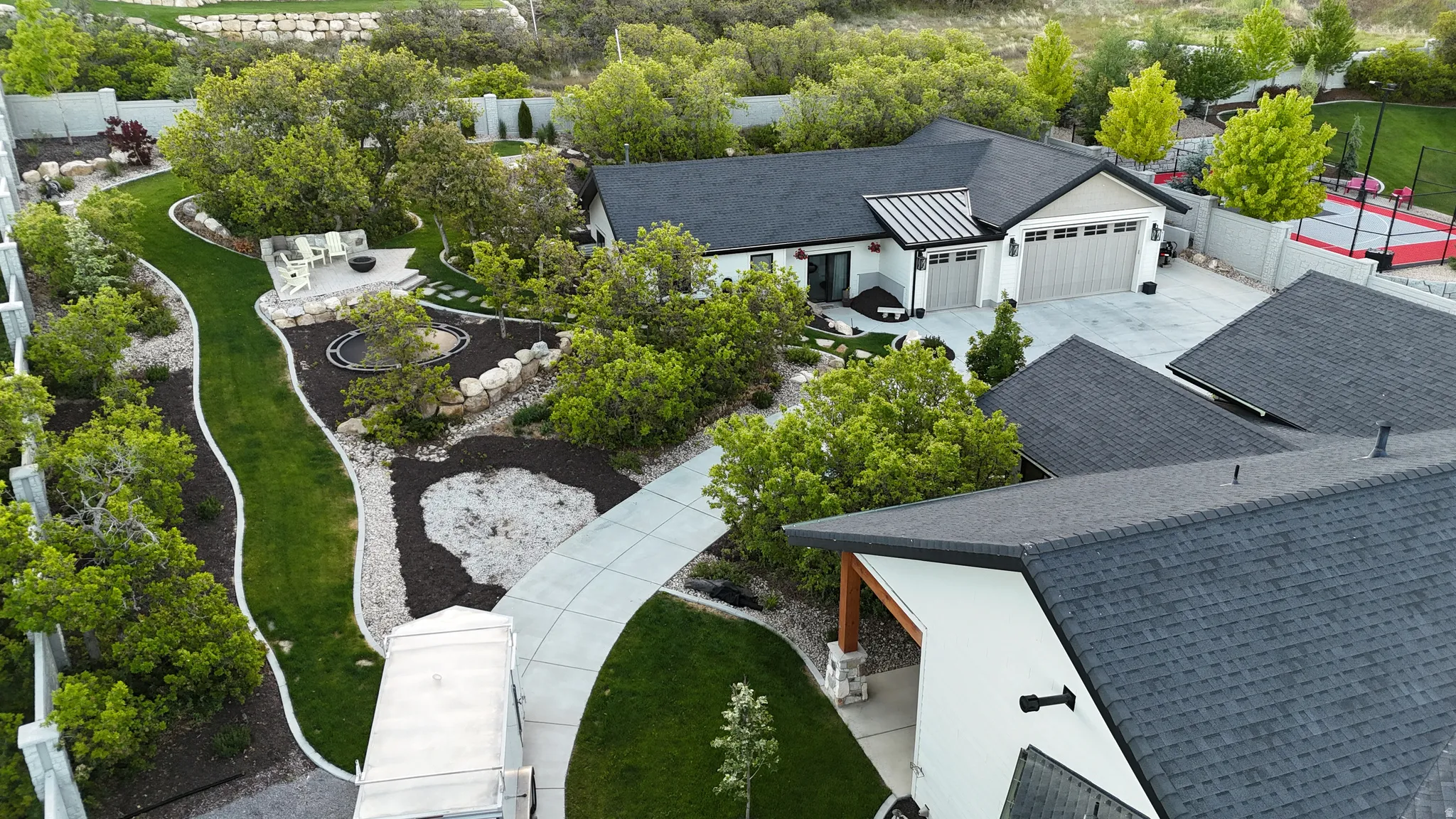 Contemporary residence featuring a dark shingled roof, white exterior siding, and a two-car garage