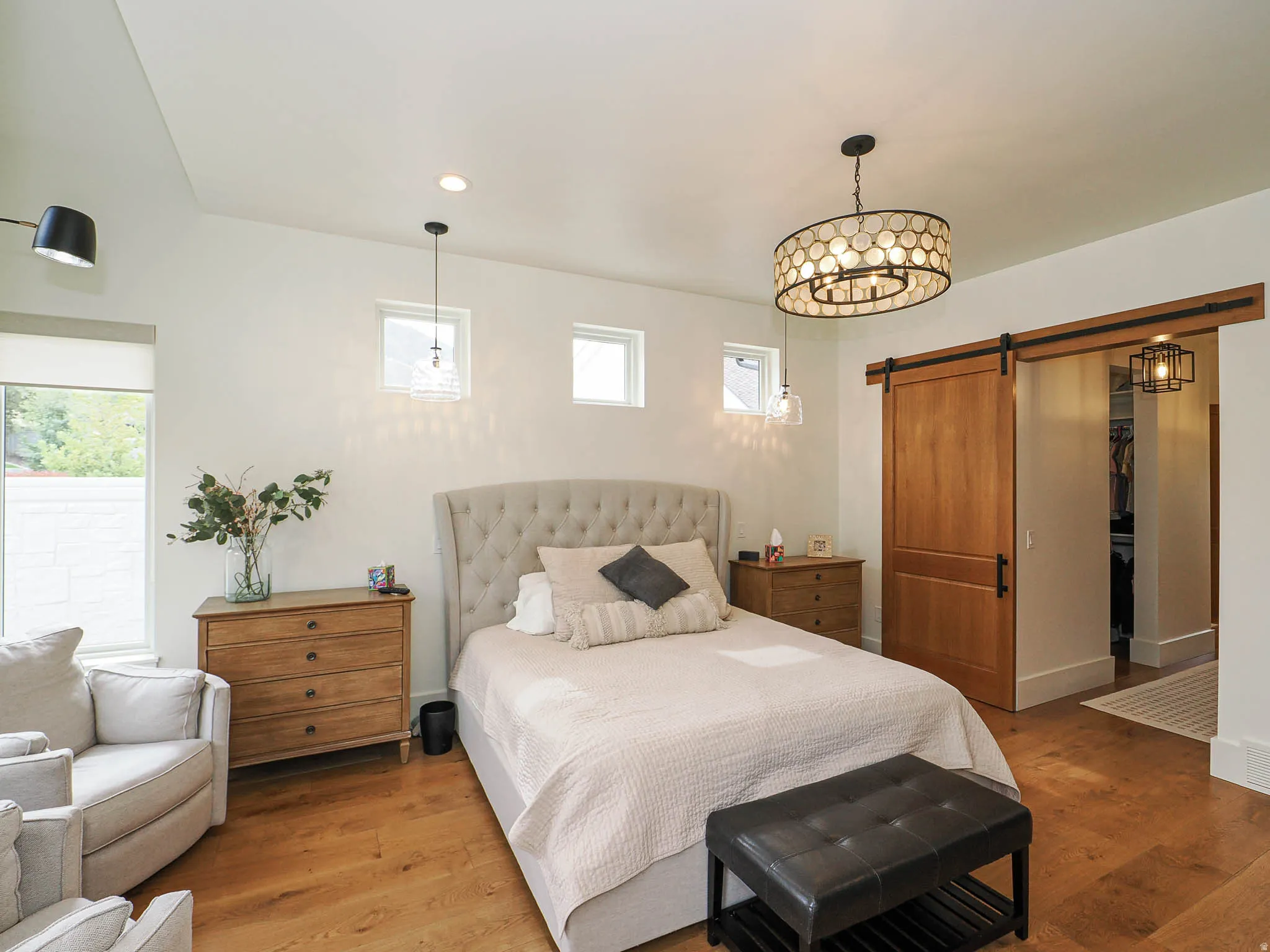 Bedroom featuring a barn door, wood finished floors, and recessed lighting