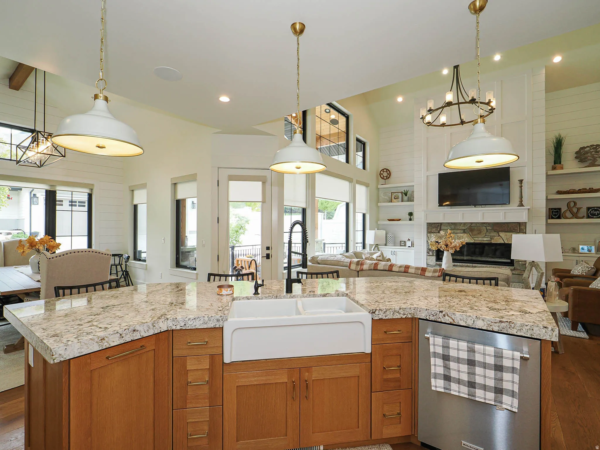 Kitchen with wood finish cabinets, open floor plan, light countertops, beverage cooler, and a high ceiling