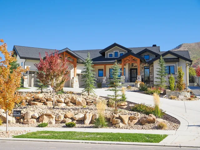 View of front of home featuring stone siding, a porch, and driveway