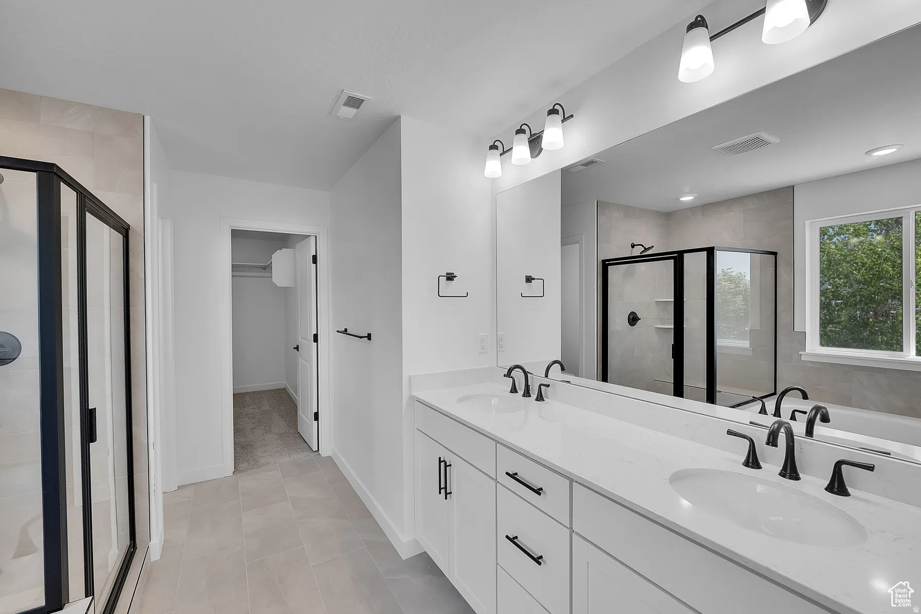 *Colors may vary** Full bath with double vanity, a shower stall, a spacious closet, and a bath