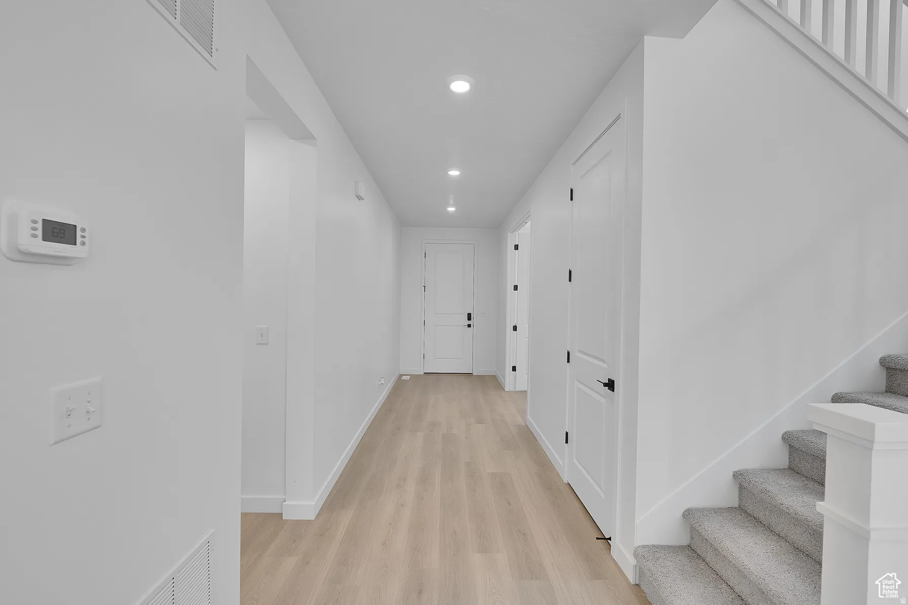 *Colors may vary** Hallway with light wood finished floors and recessed lighting