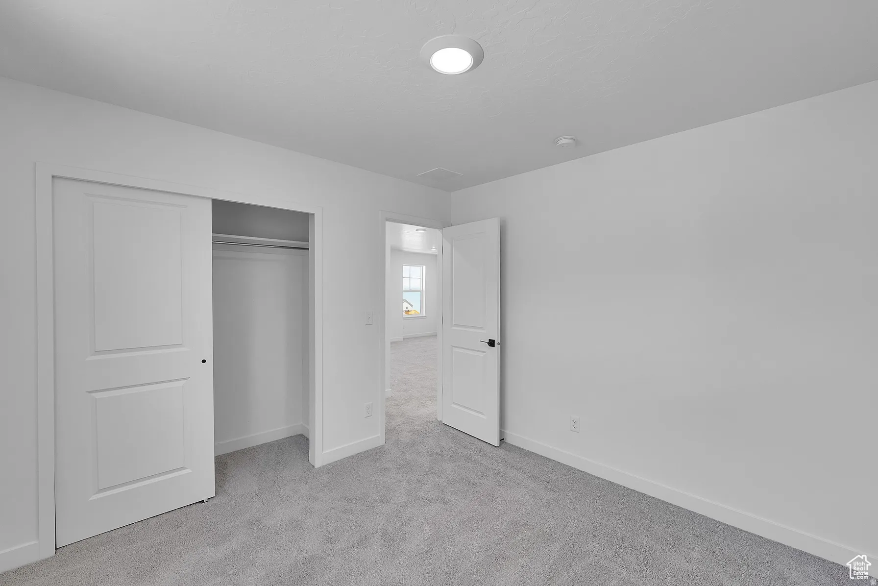 *Colors may vary** Unfurnished bedroom with light colored carpet and a closet