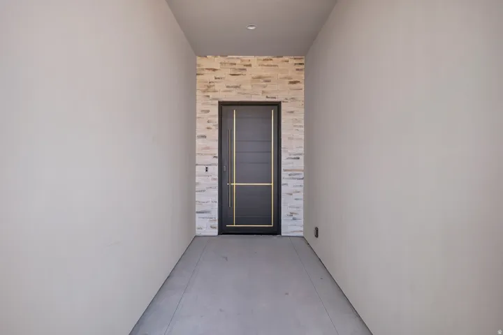 Entrance to property with a patio area and stone siding