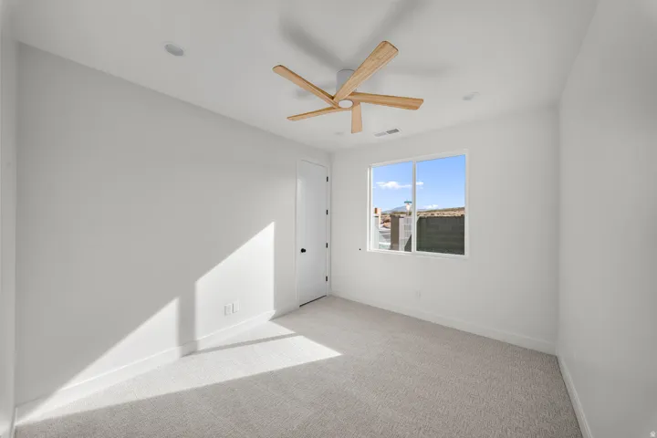 Unfurnished room featuring light carpet and ceiling fan