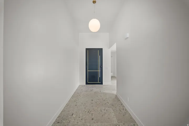 Hallway with baseboards and a high ceiling