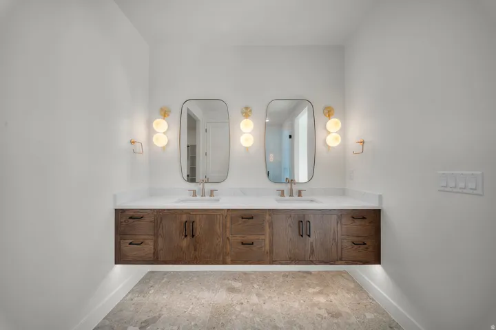 Bathroom featuring double vanity and baseboards