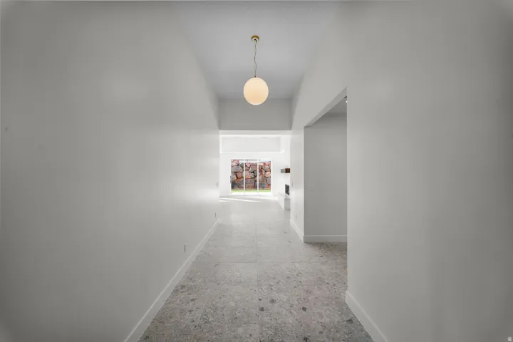 Hallway with baseboards and a high ceiling