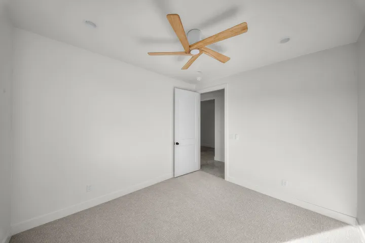 Spare room featuring light carpet and a ceiling fan