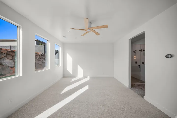 Spare room with light colored carpet and a ceiling fan