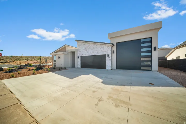Contemporary home featuring driveway, a garage, and stucco siding