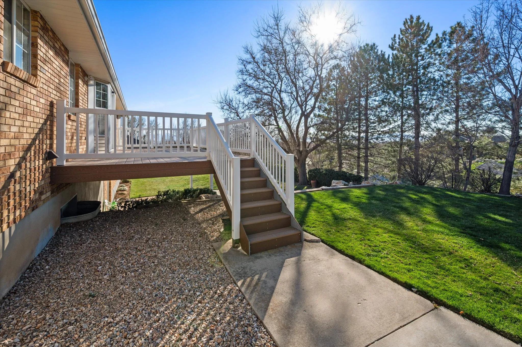 View of green lawn with stairs and a wooden deck