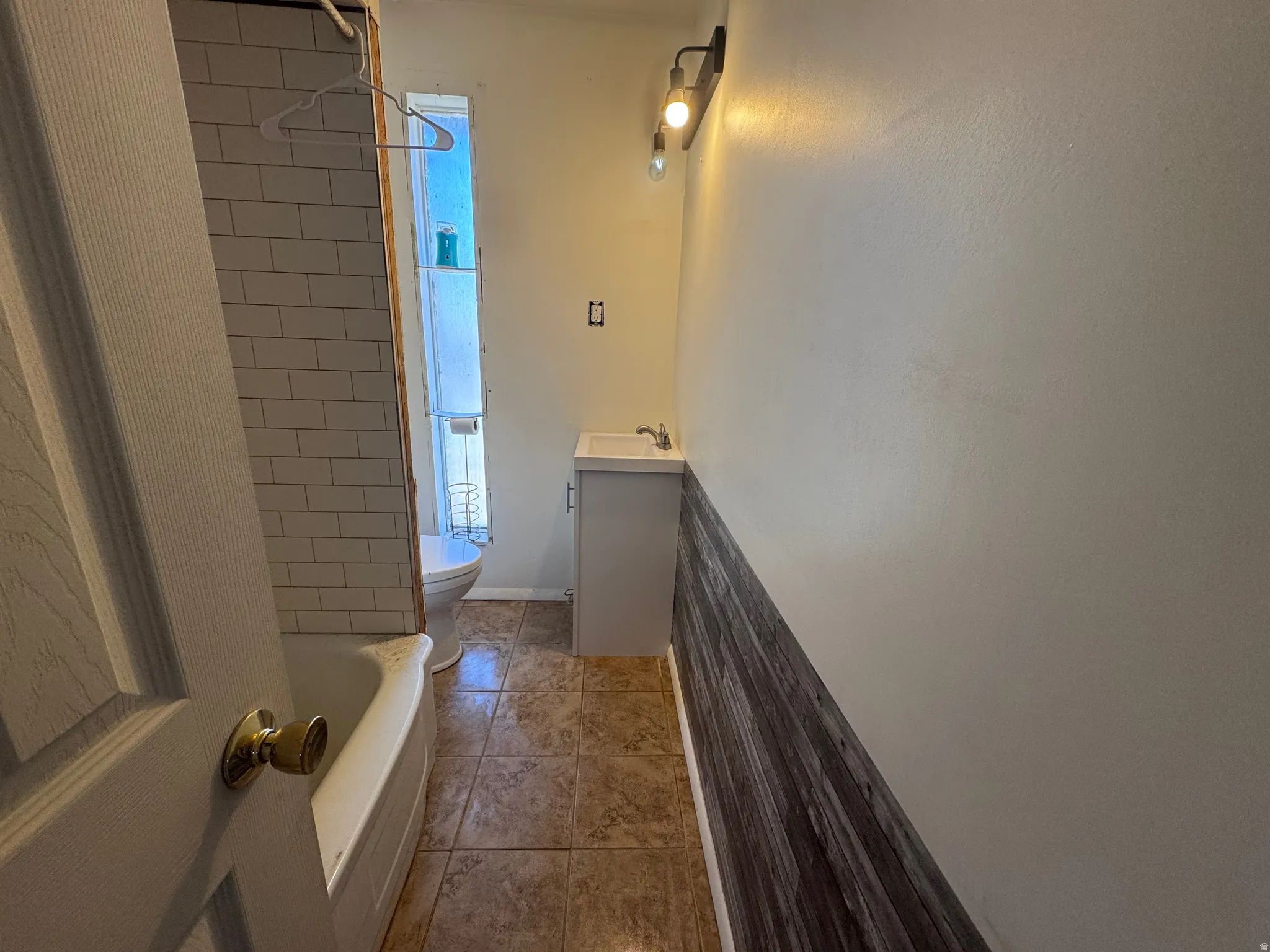Bathroom featuring vanity, light tile patterned flooring, and shower / bathtub combination