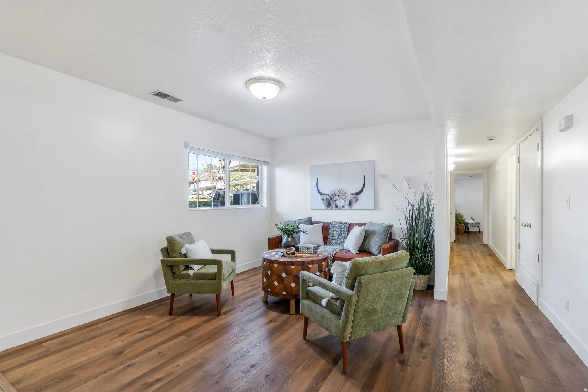 Living area featuring wood-type flooring and a textured ceiling