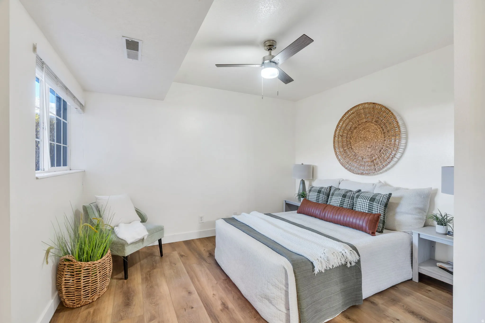 Bedroom with light wood finished floors and a ceiling fan