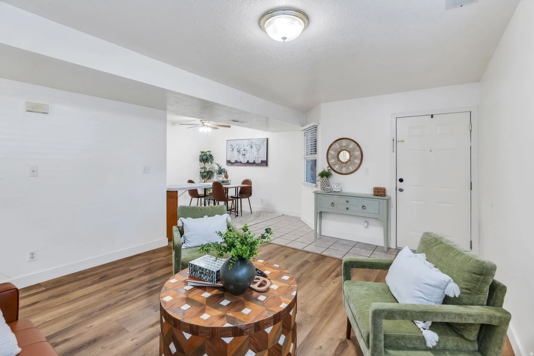 Living room with wood finished floors, a ceiling fan, and a textured ceiling