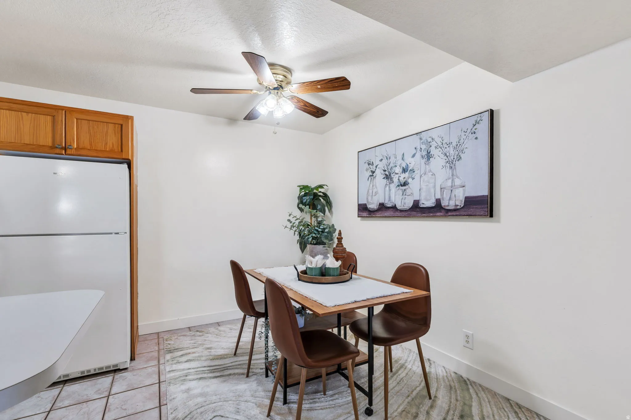 Dining area with a ceiling fan and light tile patterned flooring