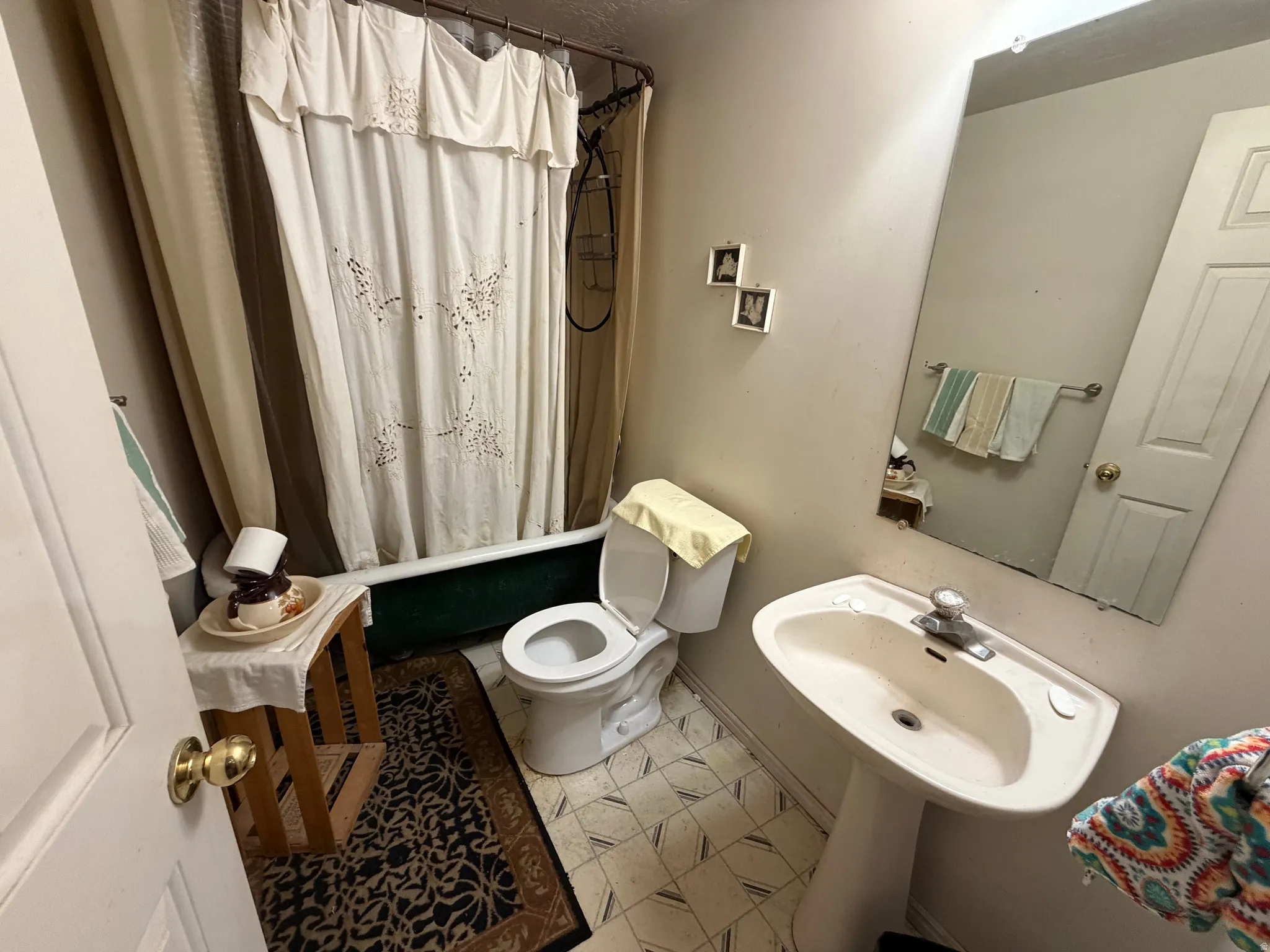 Full bathroom with toilet and shower / bath combination with curtain