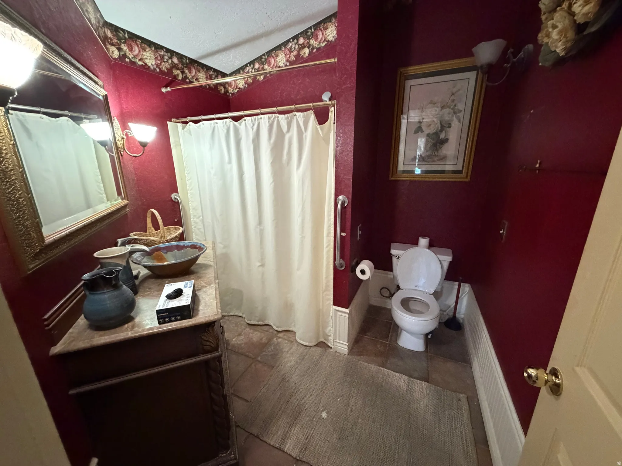 Bathroom featuring a shower with shower curtain, vanity, radiator heating unit, vaulted ceiling, and dark tile patterned floors